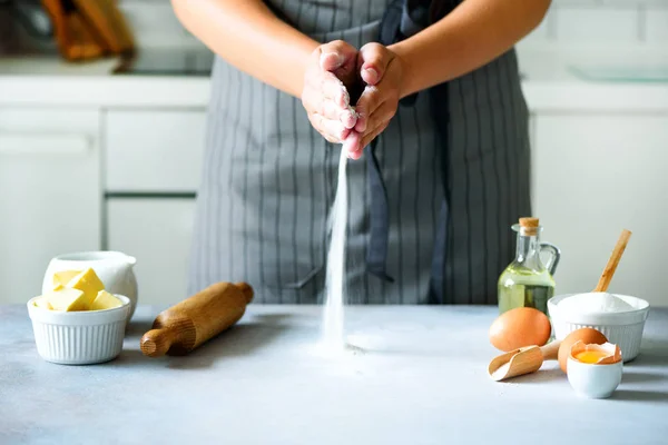 Manos femeninas amasando masa, horneando fondo. Cocinar los ingredientes - huevos, harina, azúcar, mantequilla, leche, rodillo en la cocina de estilo blanco. Copiar espacio — Foto de Stock