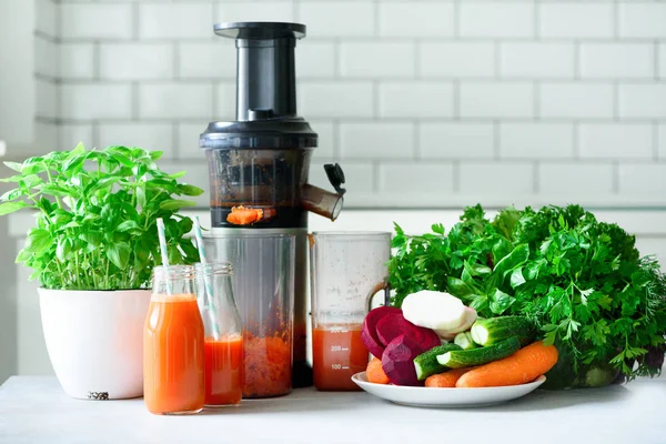 Une femme qui prépare des boissons fraîches. Jus de fruits et jus de carotte. Fruits en arrière-plan. Manger propre, concept de désintoxication — Photo