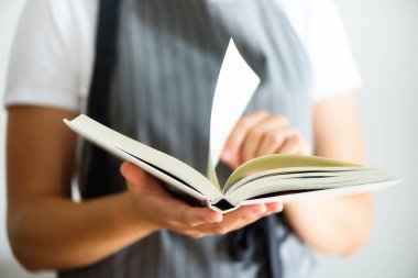 Gri önlük ve kitap okumak giyen kız. Yaşam tarzı kavramı