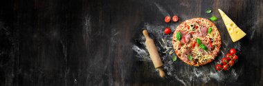Kız eller, yapım decopating fesleğen ile pizza hazırlama, koyu arka plan üzerinde bırakır. Görünümü en çok, uzay kopyalayın. Afiş