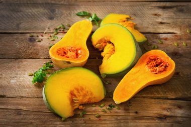 Olgun turuncu kabak tohumu ve otlar ile rustik ahşap arka plan üzerinde kesti. Vejetaryen ve ham organik sağlıklı gıda kavramı, diyet. Üstten Görünüm, kopya alanı