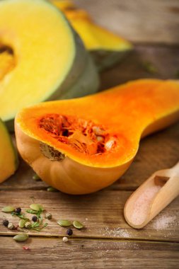 Olgun turuncu kabak tohumu ve otlar ile rustik ahşap arka plan üzerinde kesti. Vejetaryen ve ham organik sağlıklı gıda kavramı, diyet. Üstten Görünüm, kopya alanı