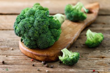 Ahşap masa üzerinde taze organik brokoli yakın çekim ile boşaltmak