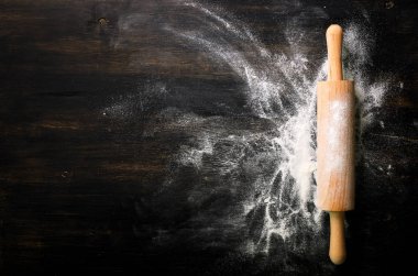 Metnin için boş alanı olan fırın arkaplanı. Siyah masaya yuvarlanan iğne ve un. Uzayı kopyala Üst görünüm