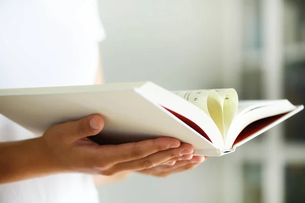 Menina em branco T-shirt leitura livro aberto com forma de coração, conceito de amor. Espaço de cópia . — Fotografia de Stock