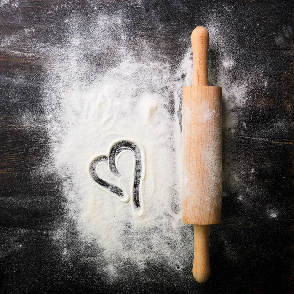 Baking background. Heart of flour and rolling pin on dark table with copy space, top view. Valentines Day — Stock Photo, Image