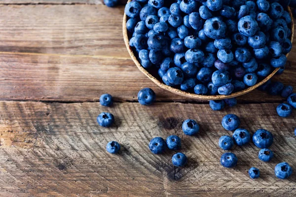 Blaubeeren auf Holztisch. Blaubeerschale auf Vintage-Hintergrund mit Copyspace. Beerenrahmen, gesundes Ernährungskonzept — Stockfoto