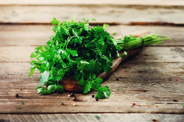 Mazzo di prezzemolo fresco biologico su fondo legno con copyspace, stile rustico e vintage, messa a fuoco selettiva, spazio libero per il testo — Foto Stock