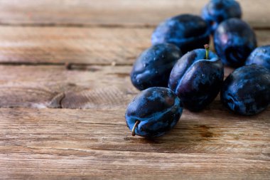 Koyu ahşap zemin üzerine mavi organik Erik. Boşaltmak