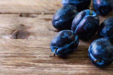 Koyu ahşap zemin üzerine mavi organik Erik. Boşaltmak