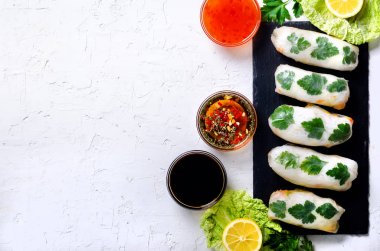 Taze Vietnamca, Asya, Çin gıda çerçeve beyaz beton zemin üzerinde. Pirinç kağıdı, marul, salata, erişte, makarna, karides, balık sosu, tatlı biber, soya, limon Çin böreği. Üstten Görünüm