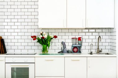 Mutfak masasının üzerinde kırmızı ve beyaz laleler taze buket. Ev iç tasarımının ayrıntılarını. Minimalist kavramı. Anne, kız, eş, kadın çiçekler. Kopya alanı.