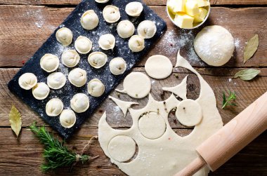 Hazırlamak, pişirmek, ev yapımı ravioli, pelmeni ya da ahşap masa manzaralı etli börek yapmak. Üst Manzara. Kırsal biçim