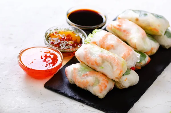 Vietnamese spring rolls - rice paper, lettuce, salad, vermicelli, noodles, shrimps, fish sauce, sweet chili, soy, lemon, veletables. Copy space. Asian and thai food. Traditional national cuisine. — Stock Photo, Image