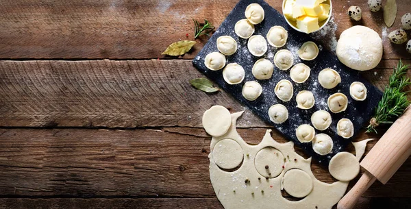 Hazırlamak, pişirmek, ev yapımı ravioli, pelmeni ya da ahşap masa manzaralı etli börek yapmak. Üst Manzara. Kırsal biçim