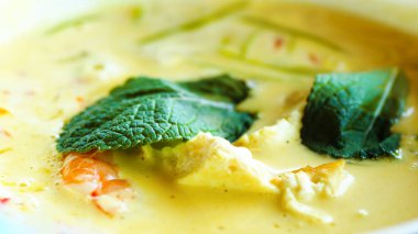 Baharatlı Hindistan cevizi sütü krem çorba köri tavuk, kaplan karides, uzun soya erişte, fasulye filizi, kireç, biber biber ve nane ile. Asya geleneksel Ulusal mutfağı, yemek tarifi. Kopya alanı