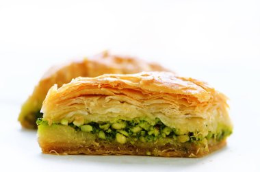 Antep fıstığı, ceviz ve beyaz zemin üzerine bal baklava. Yahudi, Türk, Arap geleneksel Ulusal tatlı. Makro. Seçici odak. Kopya alanı