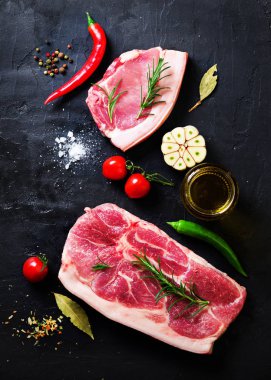 Çiğ taze et biftek domates, acı biber, sarımsak, yağ ve otlar karanlık taş, beton arka plan ile. Metniniz için boş alan
