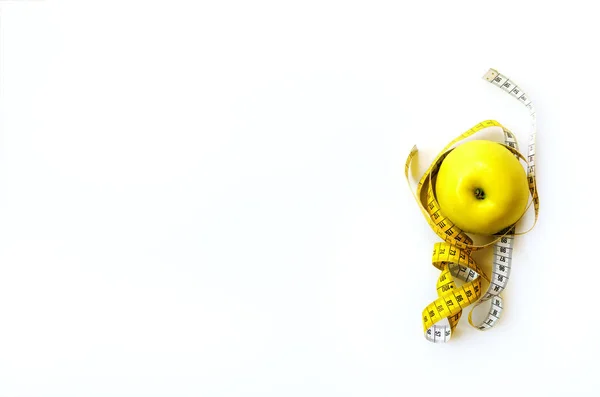 Svinovací metr kolem čerstvé chutné žluté jablko izolovaných na bílém pozadí. Dieta, hubnutí, fitness, sport koncept. Jarní a letní ovoce. Kopírovat prostoru. Nápis. — Stock fotografie