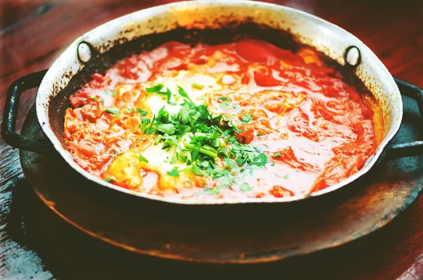 Shakshuka. Традиційні страви єврейської та близькосхідної кухонь рецепт. Смажені яйця, помідори, солодкий перець і петрушкою на сковороді. Крупним планом, вибіркове фокус. Тоноване ефект — стокове фото