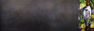 Taze çiğ balık, dorado, çipura limon, otlar, sebzeler ve baharat taş zemin üzerine. Üstten Görünüm. Afiş