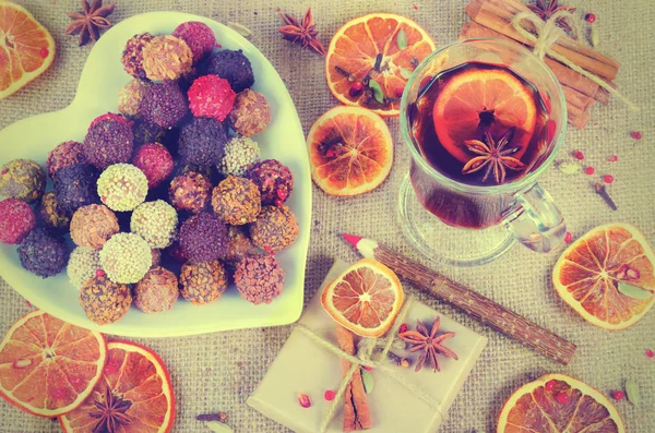 Collection de bonbons au chocolat faits à la main, oranges séchées, épices, vin chaud, crayon en bois sur fond en bois . — Photo