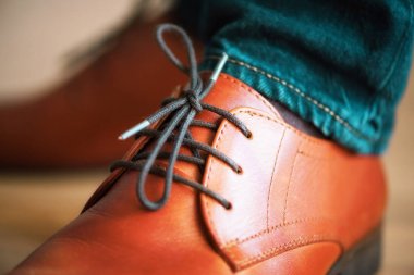 İşadamı kahverengi deri ayakkabı bağcıkları ahşap parke zemin ile. Stil ve moda kavramı.