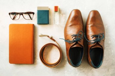 Mens aksesuarları ve gri arka plan üzerinde ayakkabı. Zarif kemer, gözlük, parfüm, defter düz yatıyordu. Adam için şık set ve moda kavramı.