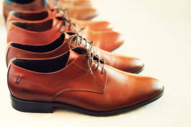 Farklı modelleri ve ayakkabı gay arka plan üzerinde kahverengi renkler. Seçici odak. Satış ve alışveriş kavramı. Uzay kopyalayın. Afiş. Klasik moda erkek kahverengi ayakkabı cilalı.