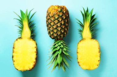 Taze ananas ve mavi arka plan üzerinde meyve yarım dilim. Üstten Görünüm. Uzay kopyalayın. Parlak ananas desen en az stil için. Pop sanat tasarım, yaratıcı kavramı