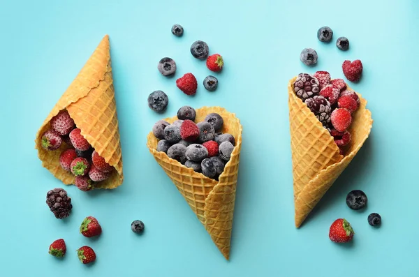 Frozen berries - strawberry, blueberry, blackberry, raspberry in waffle cones on blue background. Top view. Banner. Pattern for minimal style. Pop art design, creative concept — Stock Photo, Image