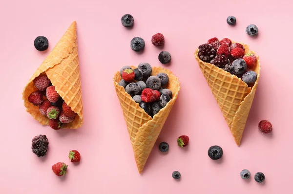 Frozen berries - strawberry, blueberry, blackberry, raspberry in waffle cones on pink background. Top view. Banner. Pattern for minimal style. Pop art design, creative concept — Stock Photo, Image