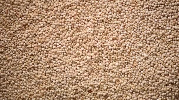 Grani di quinoa organici grezzi su fondo rotante. Struttura dei semi. Sfondo ingrediente alimentare. Vista dall'alto, concetto di stile di vita sano — Video Stock