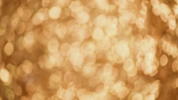 Glänzende abstrakte strukturierte Hintergrund mit goldenen Lichtern, Bokeh. Weihnachten, Neujahr. Festliche Goldkulisse — Stockvideo