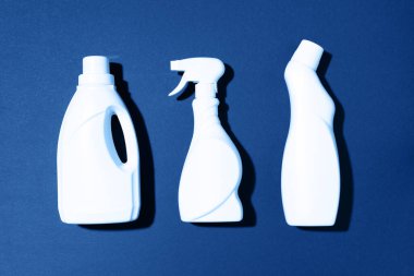 Klasik mavi arka planda temizlik ürünleri. Üst Manzara. Uzayı kopyala Kimyasal temizlik malzemeleri. Plastiği, geri dönüşümü, ayrı çöp konsepti koleksiyonunu durdur