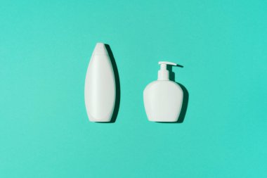 Mavi arka planda şampuan ve sabun şişeleri. Üst Manzara. Düz yatıyordu. Boşluğu kopyala.