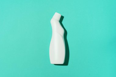 Beyaz plastik temizlik ürünü şişesi, ev kimyasalları ya da mavi arka planda sıvı çamaşır deterjanı. Üst Manzara. Düz yatıyordu. Uzayı kopyala Deterjan şişesi.