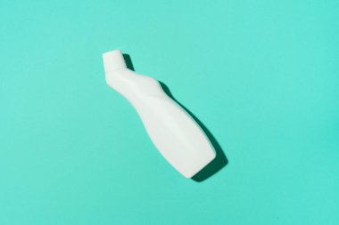 Beyaz plastik temizlik ürünü şişesi, ev kimyasalları ya da mavi arka planda sıvı çamaşır deterjanı. Üst Manzara. Düz yatıyordu. Uzayı kopyala Deterjan şişesi.