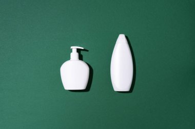 Yeşil arka planda şampuan ve sabun şişeleri. Üst Manzara. Düz yatıyordu. Boşluğu kopyala.