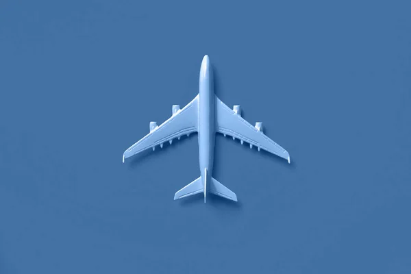 Bílé letadlo, letadlo v módní modré a klidné barvě. Duhový přechod pozadí s kopírovacím prostorem. Pohled shora, plochý. Minimální design stylu. Cestování, dovolená koncept. — Stock fotografie