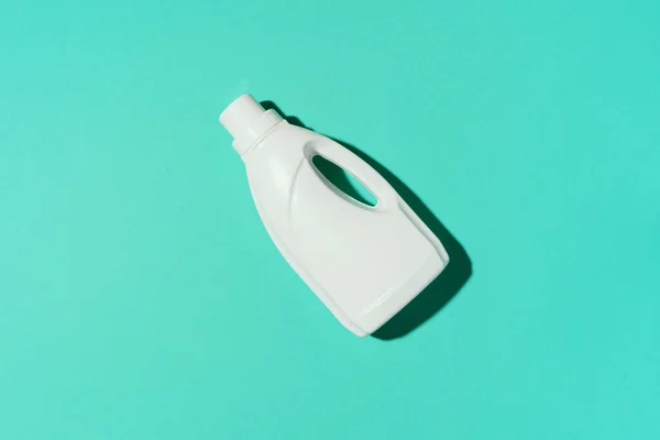 Біла пластикова пляшка очищувального продукту, побутової хімії або рідкого прального порошку на синьому фоні. Вид зверху. Пласка лежала. Копіювати простір. Пляшка для миючих засобів — стокове фото