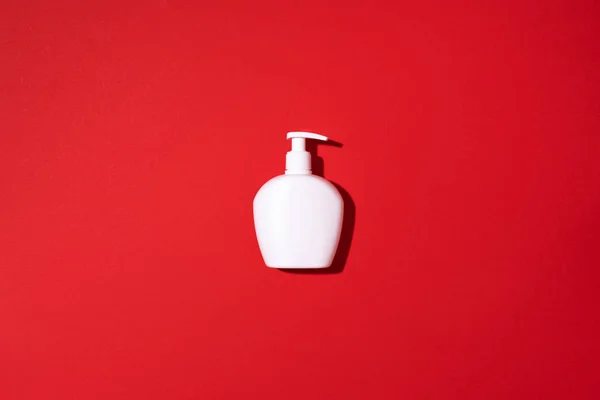 Shampoo dan botol sabun dengan latar belakang merah. Pemandangan bagus. Berbaringlah. Salin ruang. — Stok Foto