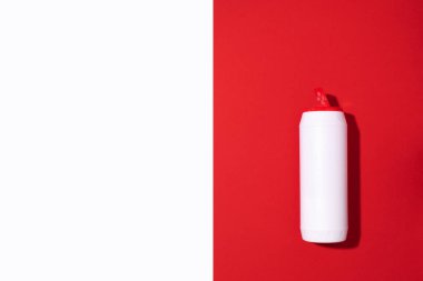 Beyaz plastik deterjan şişesi ya da kırmızı arka planda temizlik maddesi. Uzayı kopyala Üst Manzara. Düz yatıyordu. Ev kimyasalları konsepti