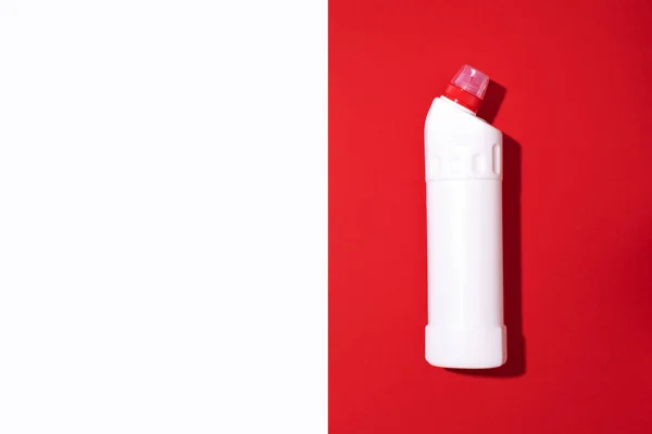 Botol plastik putih produk pembersih, bahan kimia rumah tangga atau deterjen cucian cair pada latar belakang merah. Pemandangan bagus. Berbaringlah. Salin ruang. Botol deterjen — Stok Foto