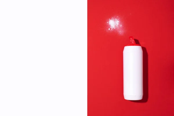 Frasco de plástico blanco de detergente en polvo o agente limpiador sobre fondo rojo. Copiar espacio. Vista superior. Acostado. Concepto de productos químicos domésticos — Foto de Stock