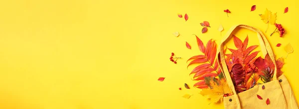 Herfst platte lay compositie. Droog esdoorn herfstblad in gele boodschappentas op gele achtergrond. Bovenaanzicht. Begrepen, ruimte. Vlakke plaat. — Stockfoto
