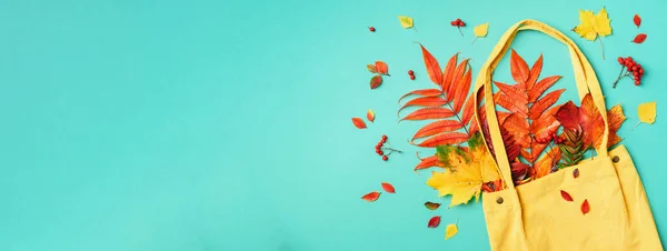 Осенняя плоская композиция. Сухие кленовые осенние листья в синей сумке покупок на желтом фоне. Вид сверху. Принято. Плоский лежал . — стоковое фото