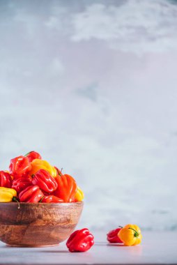 Gri arka planda ahşap kasede kırmızı biberli renkli İskoç şapkası. Boşluğu kopyala.