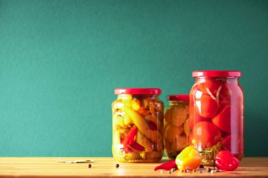 Yeşil arka planda cam kavanozlarda saklanmış sebzeler. Uzayı kopyala Sağlıklı mayalanmış gıda konsepti. Hasat konsepti