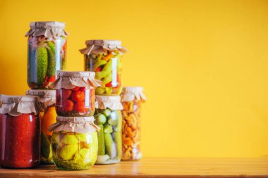 Turuncu arka planda cam kavanozlarda saklanmış sebzeler. Uzayı kopyala Sağlıklı mayalanmış gıda konsepti. Hasat konsepti